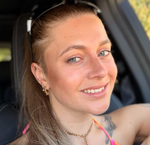 Porträt einer jungen, lächelnden Frau im Auto