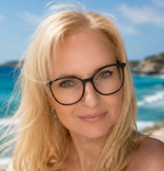 Porträt einer blonden Frau mit Brille vor dem Meer