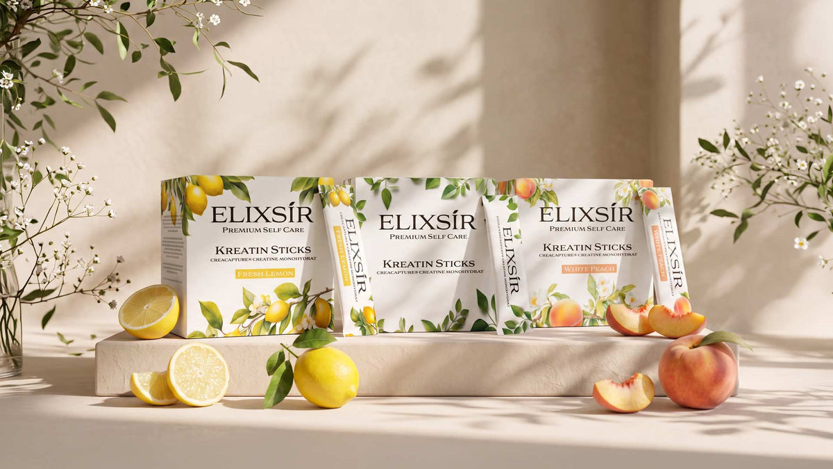 Die drei Elixsír Kreatin Sticks Sorten Fresh Lemon, Pure und White Peach auf Steinpodest mit Zitronen, Pfirsichen und Zweigen