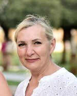 Porträt einer blonden Frau in weißer Bluse in einem Park